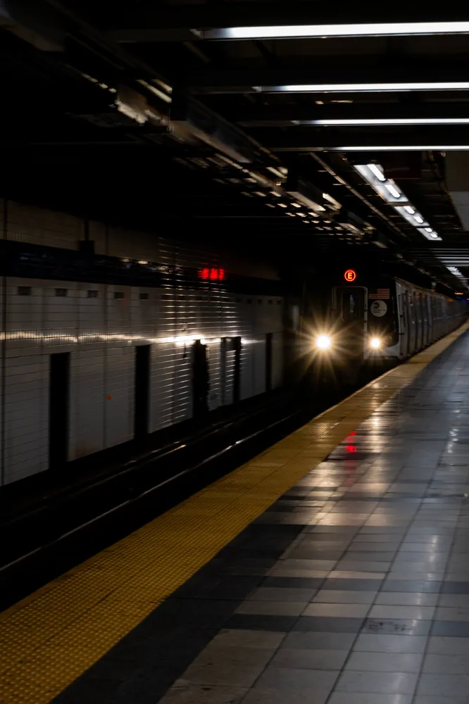 Headlights approaching a dark subway platform