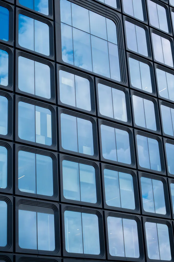 Blue sky and clouds reflected in a glass building facade